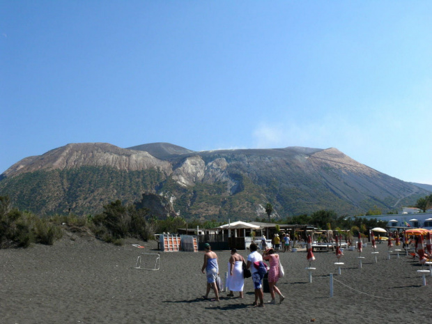 Vulcano - czarna plaża z dymiącym wierzchołkiem wulkanu w tle #Sycylia #WyspyLiparyjskie